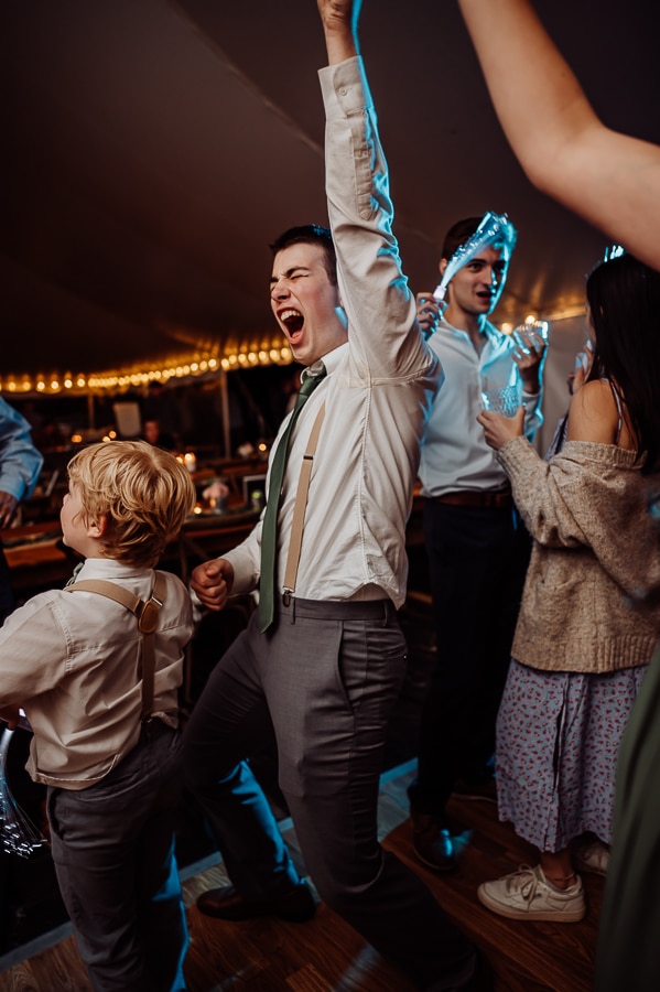 Groom dancing and jumping on dance floor at wedding
