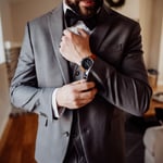 Groom fixing cuff links with a watch on his wrist