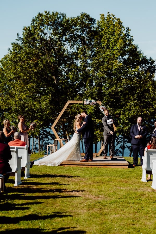 bride and groom first kiss at alter