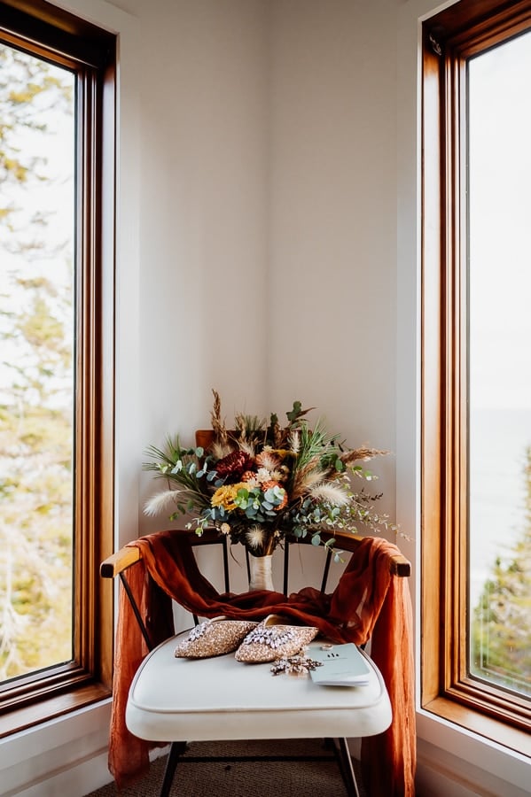 Flowers and shoes sitting in chair in the corner