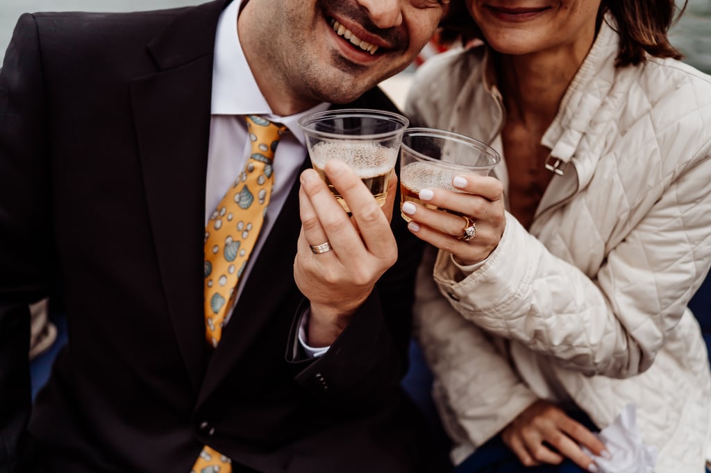 Bride and groom sharing champagne cheers on a boat