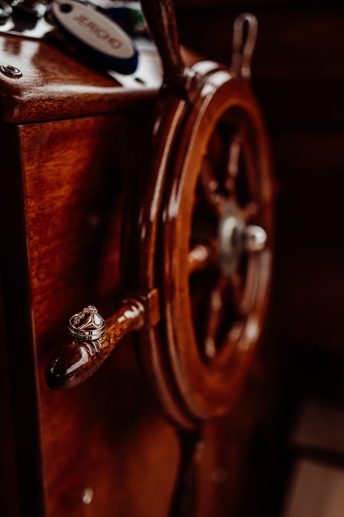 Wedding Rings sitting on captains wheel on Jericho boat