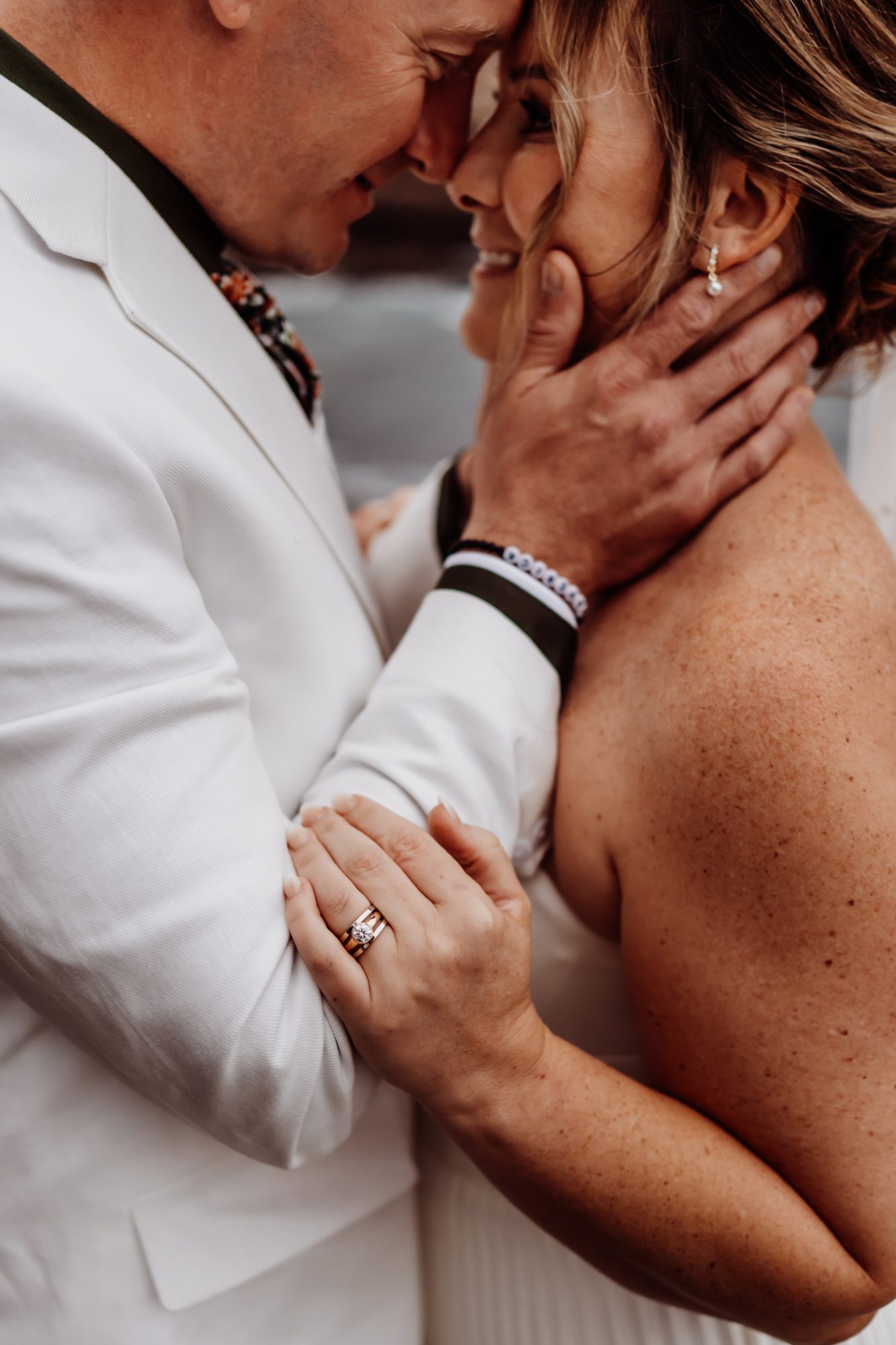 Close-up of bride and groom holding hands during their Thunder Hole elopement.