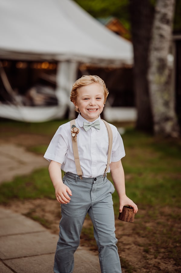Ring bearer walking down isle at wedding in weld maine