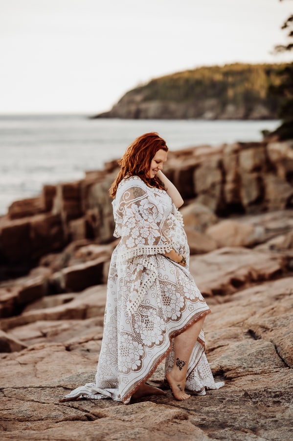 Woman wearing white lace dress in bar harbor on cliffs