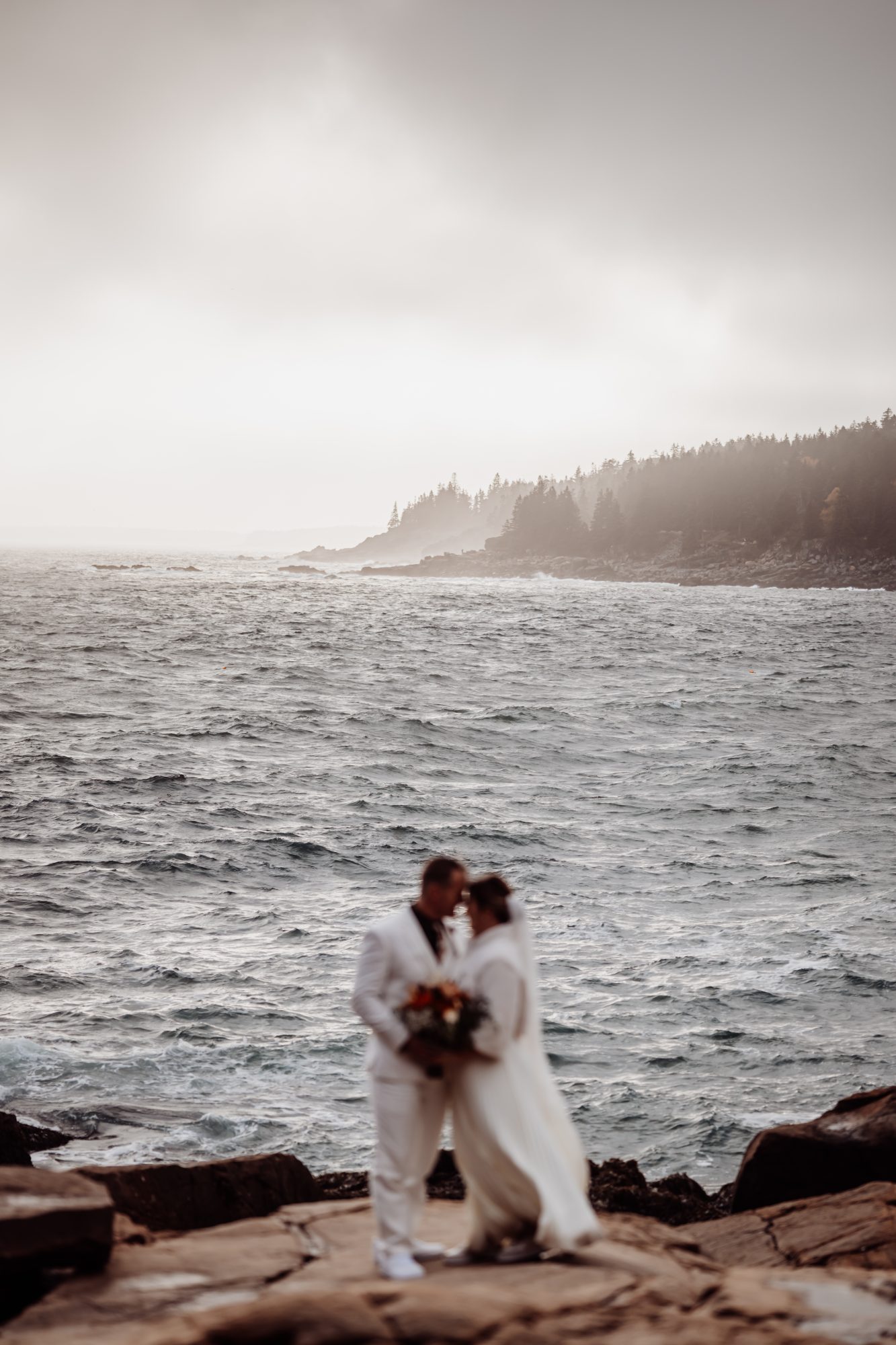 Romantic coastal portrait with Atlantic Ocean waves during Acadia National Park elopement.
