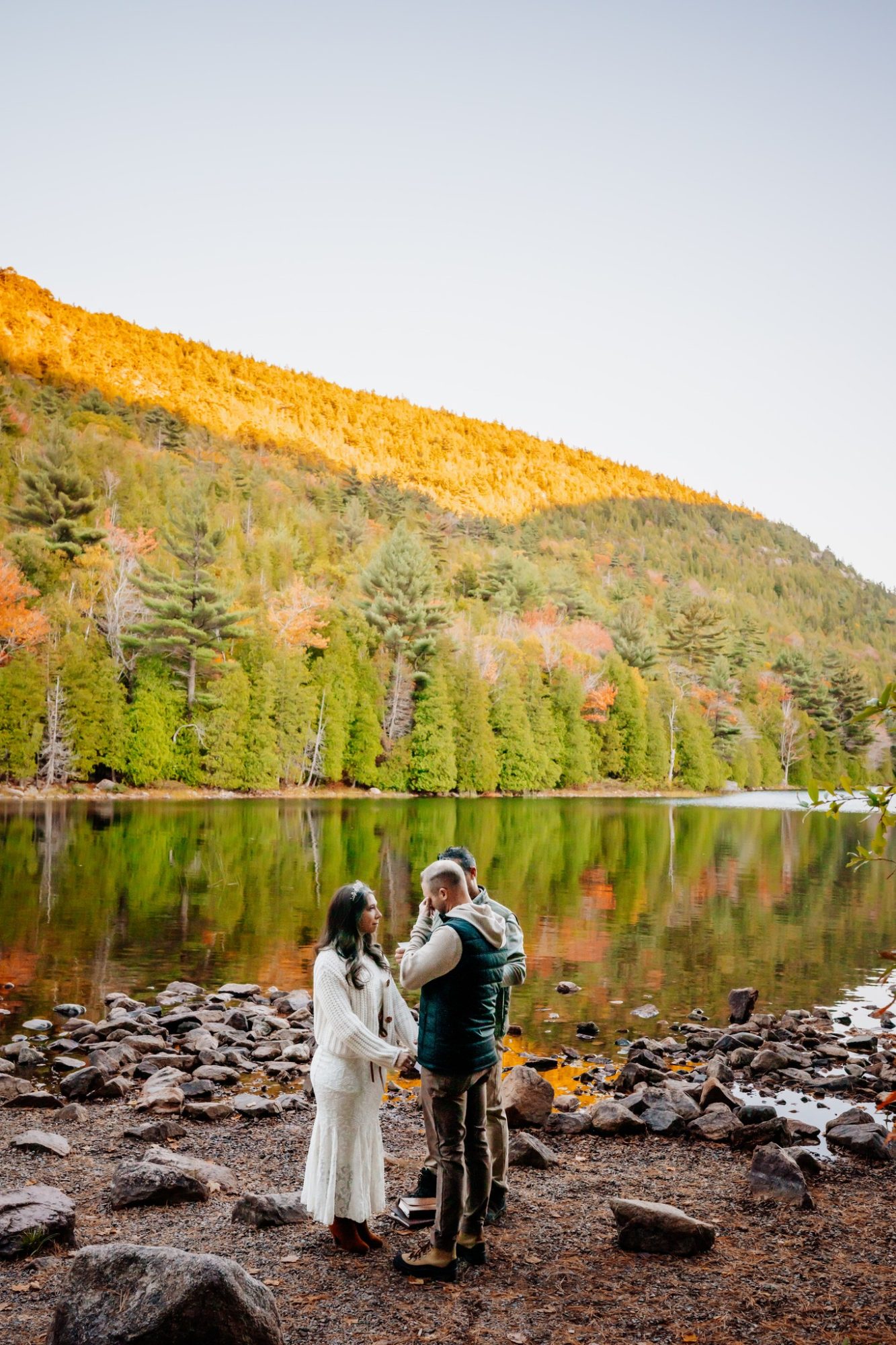 Couple at Jordan Pond with vibrant fall foliage during Acadia National Park elopement.