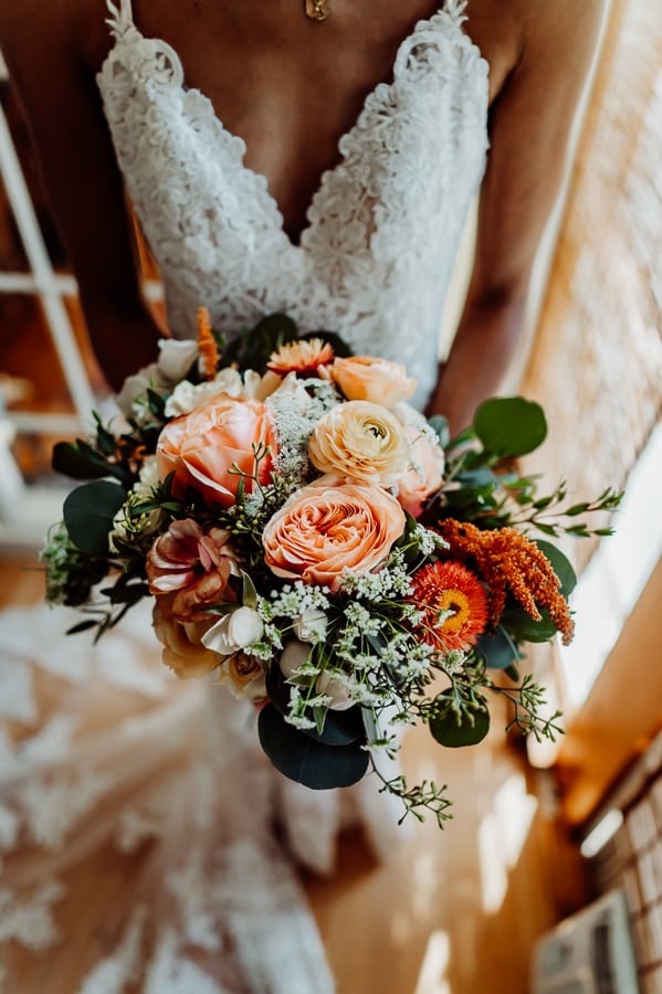 Woman holding flower arrangement at wedding in walpole maine