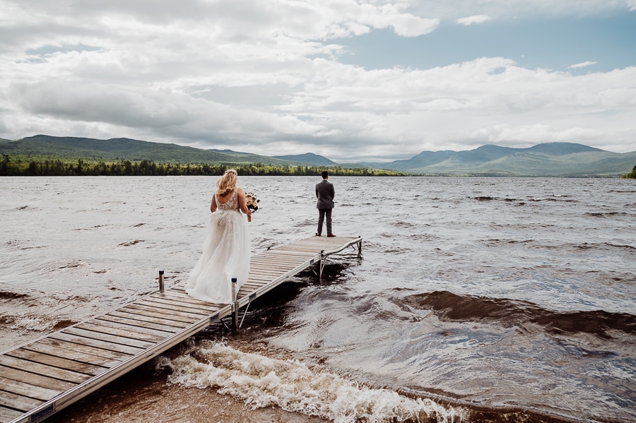 bride walking on dock for first look with groom on lake