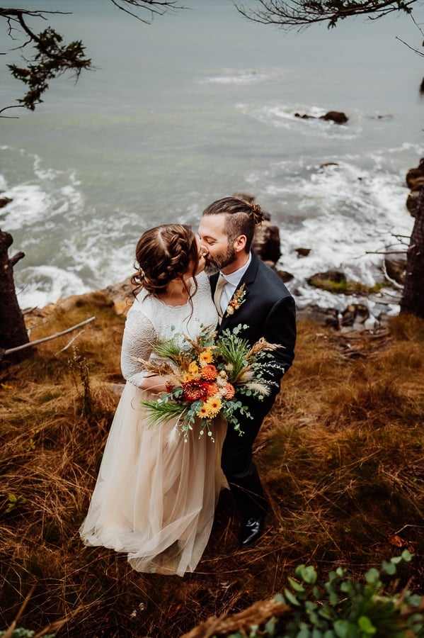 bride and groom kissing on coastal ledge in machiasport maine
