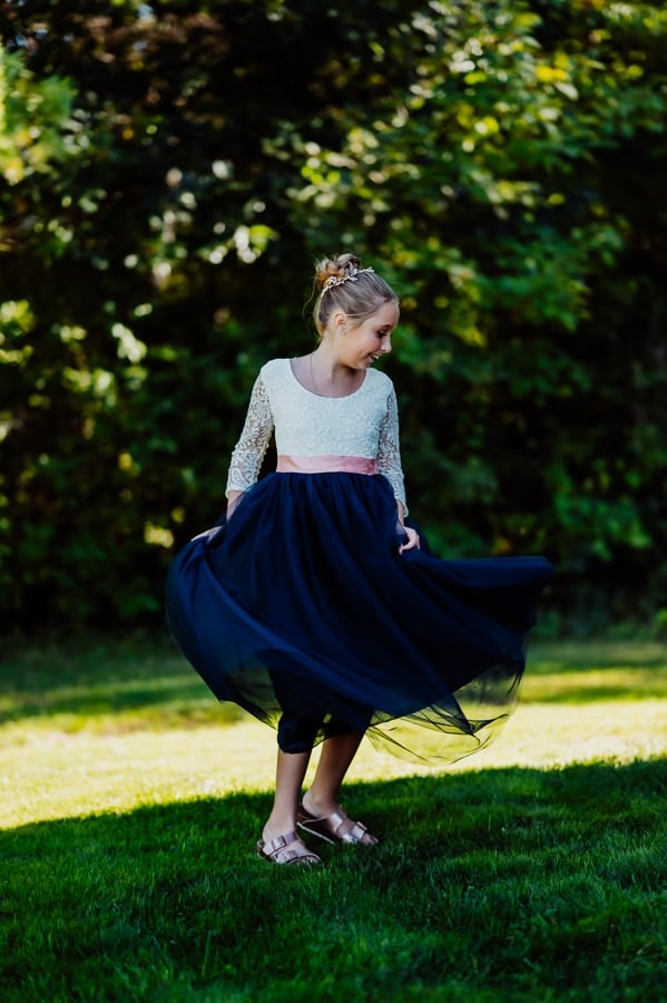 flower girl wearing a blue and white dress twirling