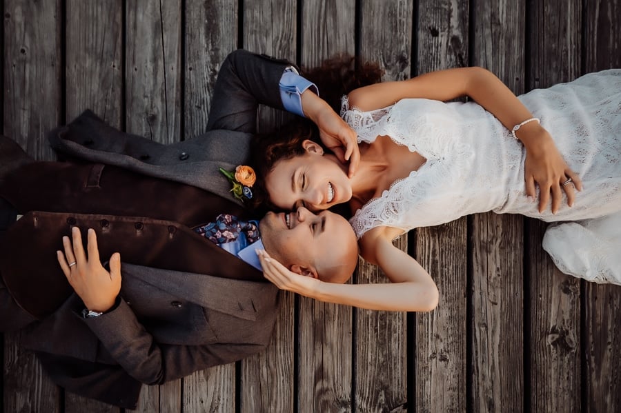 Room laying on a dock together holding each other's faces