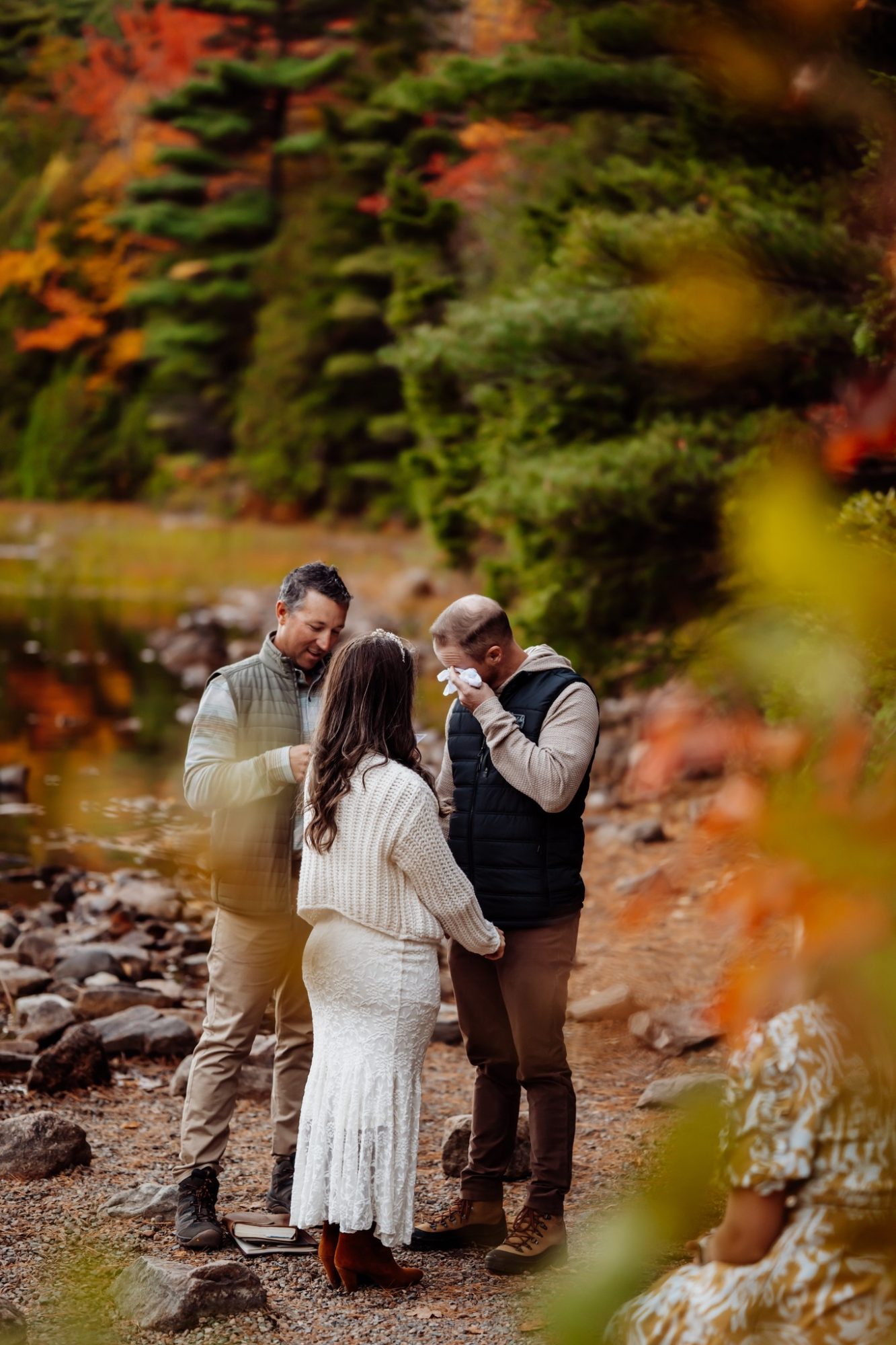 Emotional vow moment framed by golden leaves during Acadia fall ceremony