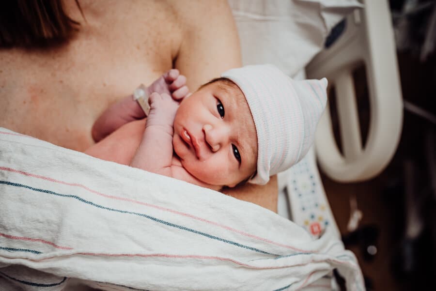 Newborn baby look at camera after birth in hospital