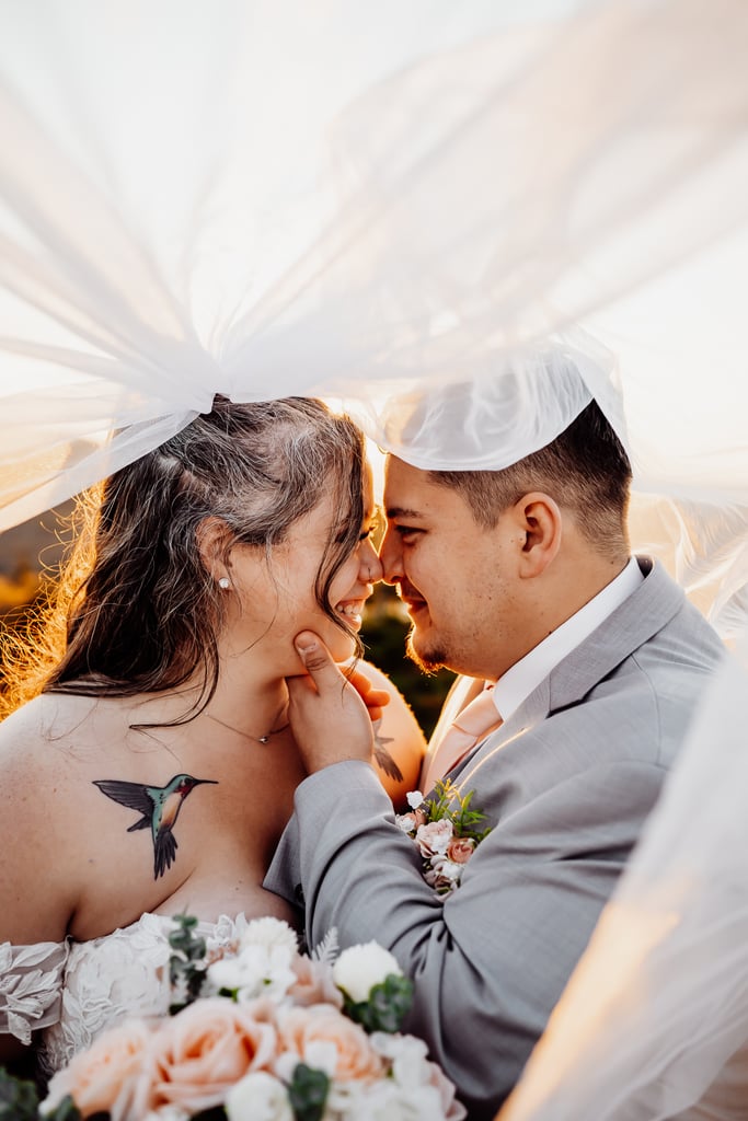Groom holding brides chin and touching noses under the veil