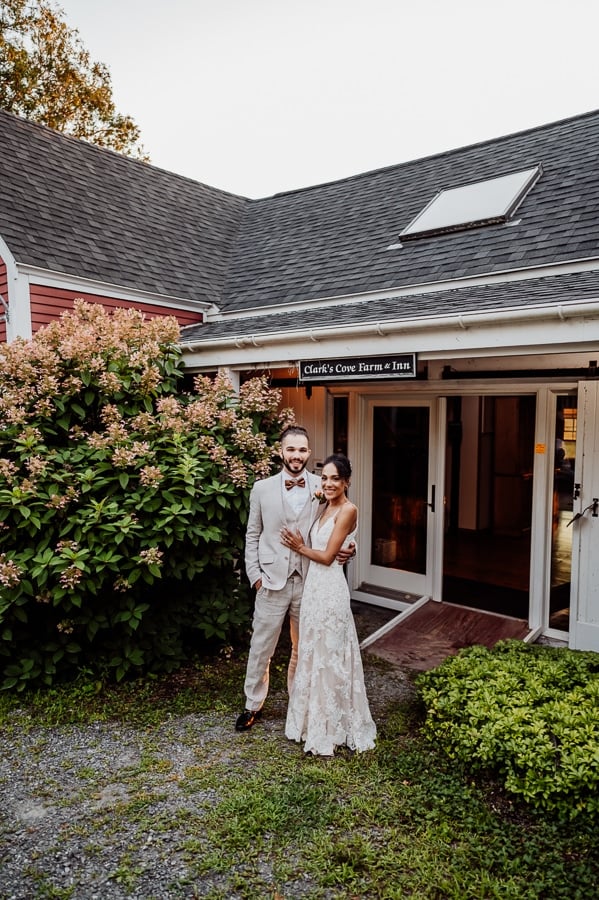 Bride and groom at entrance to Clarks cove farm inn sign