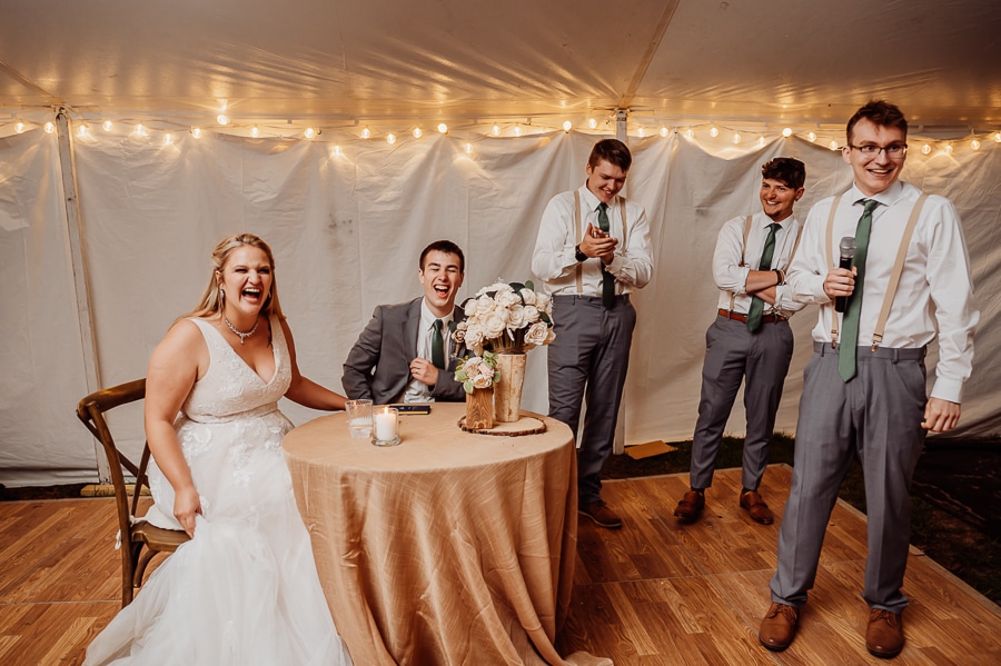 Speeches being given at wedding reception under tent