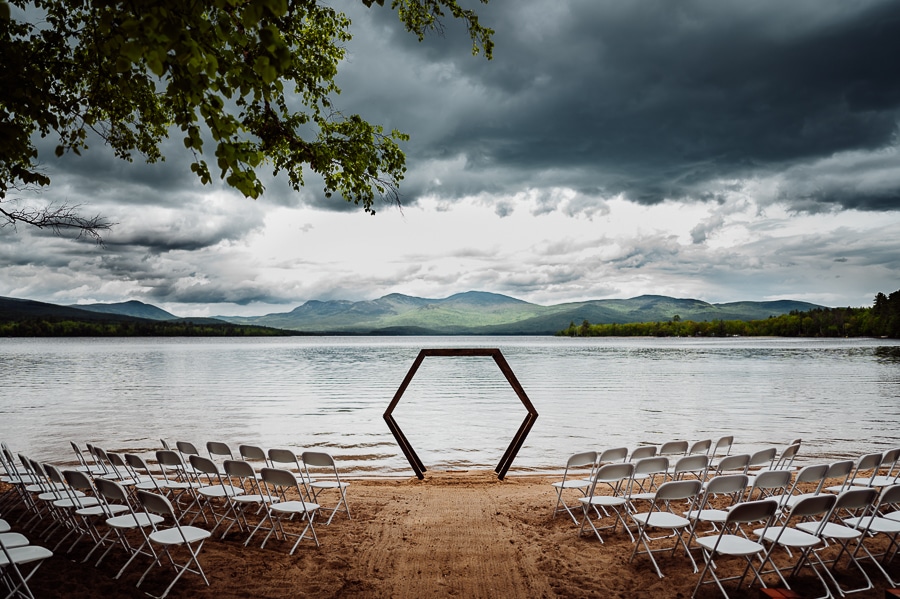 Octagon wedding alter and chairs in front of lake with dark moody sky
