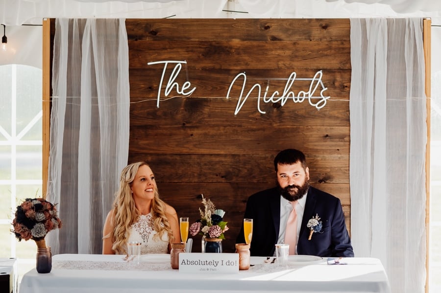bride and groom sitting at head table