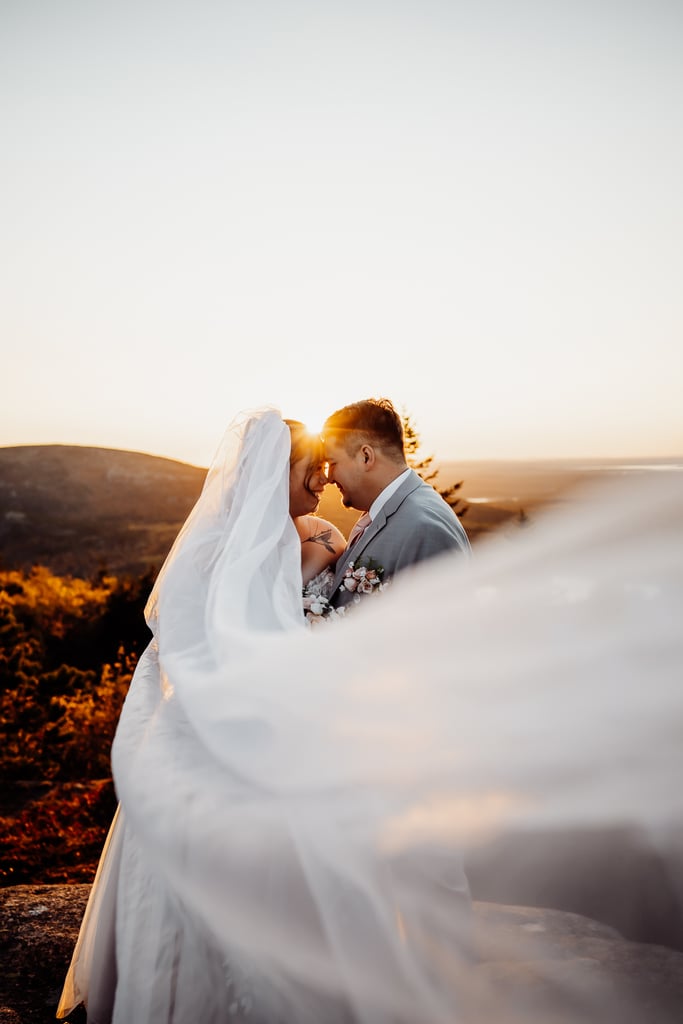 Bride and groom touching heads with a veil wrapping around towards the camera