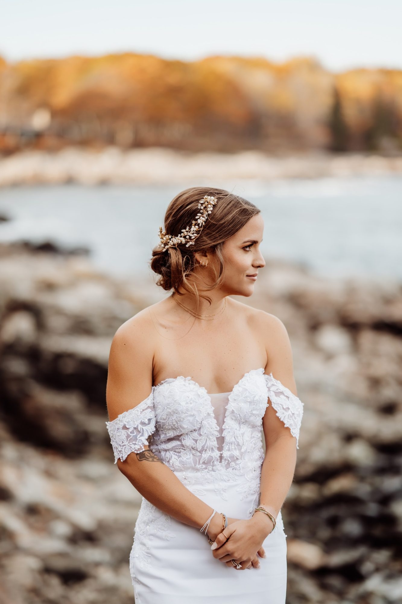 Bride portrait at Schooner Head Overlook in Acadia National Park with soft wind in her hair and rocky Maine coastline behind her.