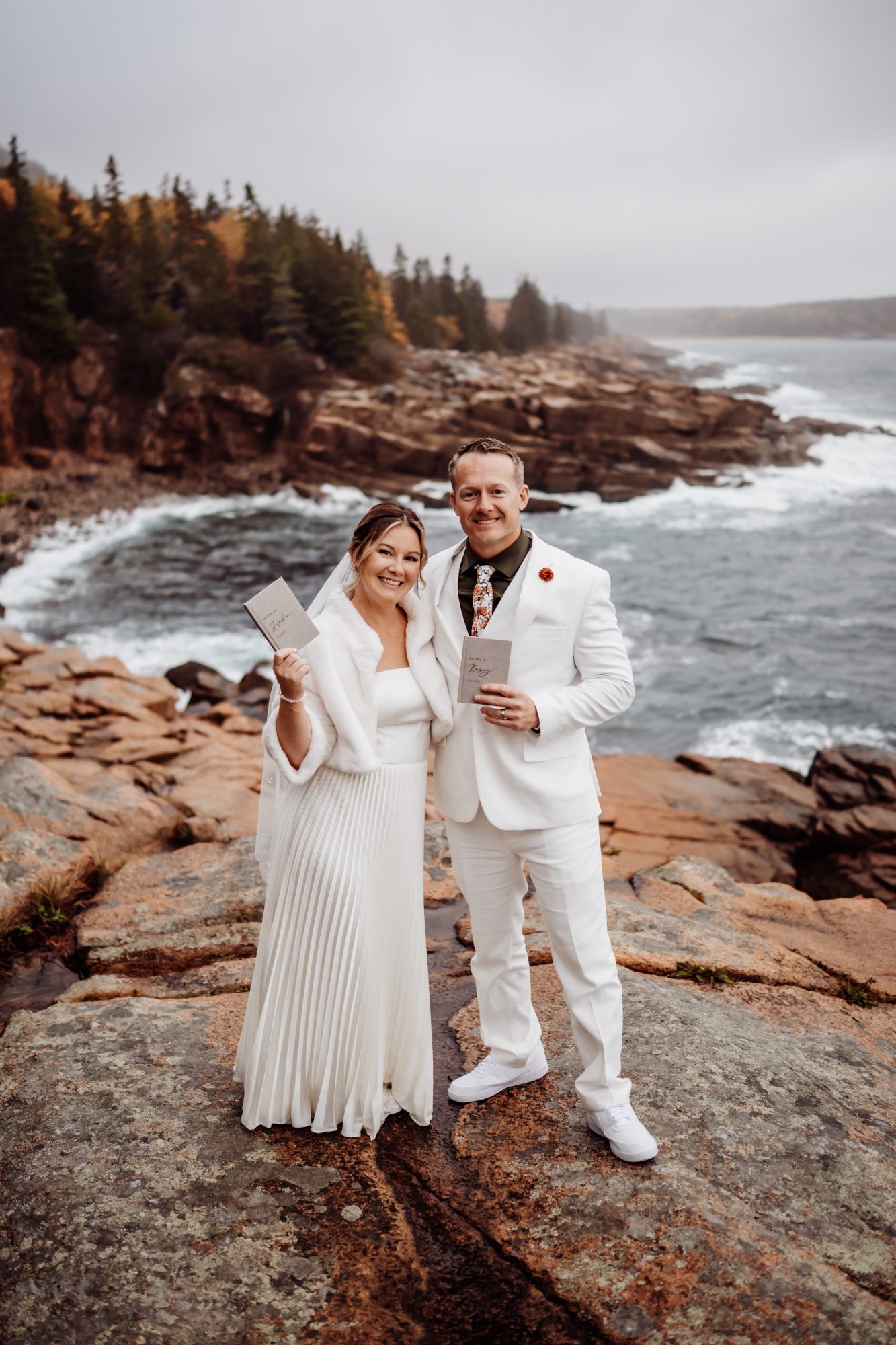 ewly married couple celebrating on rocky coastline at Thunder Hole in Acadia National Park.