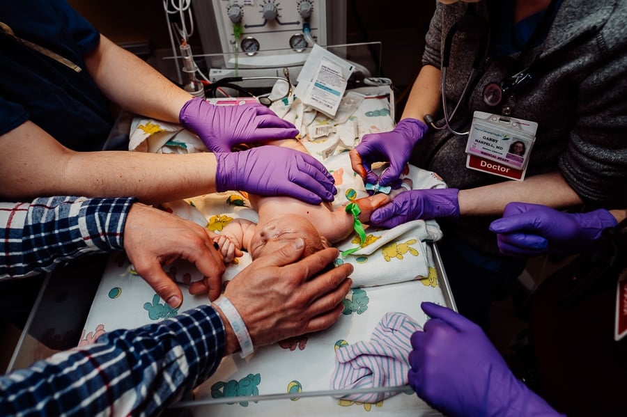 Newborn baby laying in warmer getting bloodwork