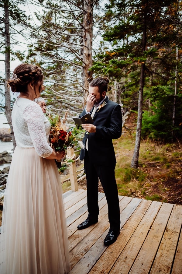 groom saying vows and wiping tears away