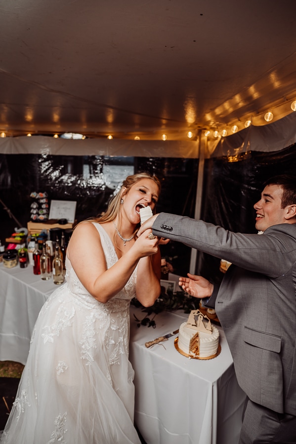 Groom feeding a piece of cake to bride at wedding