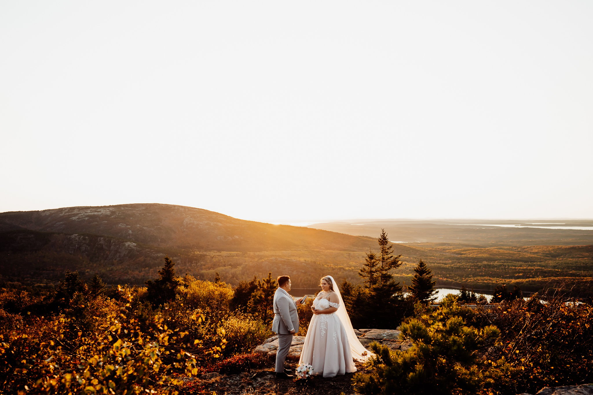 Groom reading his vows to his bride on the top of the mountain