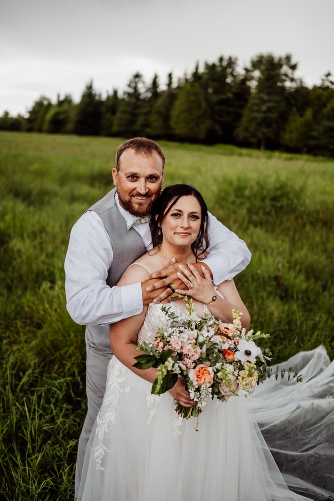 Groom standing behind Bride with arms wrapped around her shoulders