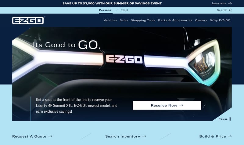 E-Z-GO homepage hero featuring a close-up of a vehicle front end with illuminated headlights and a Reserve Now call to action