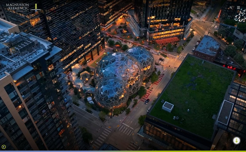 Magnusson Klemencic Associates homepage hero, a dusk aerial photograph of the Amazon Spheres in Seattle filling the screen, with only a logo, search icon, and menu icon over it