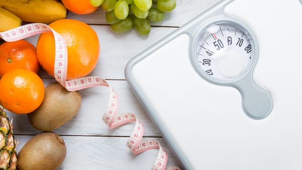 Scale and healthy foods representing lifestyle changes for healthy weight loss