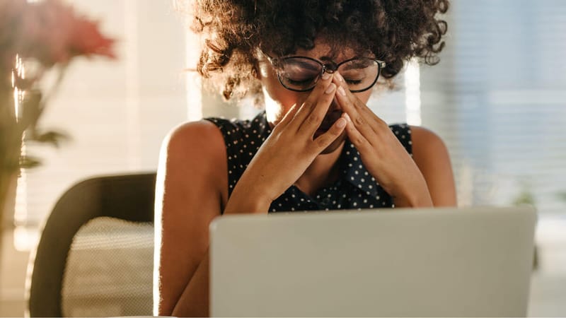 A person looking at a computer and experiencing sensory sensitivities