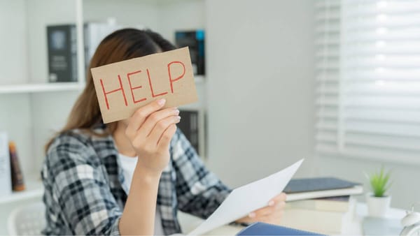 A person with sensory processing challenges holding up a help sign