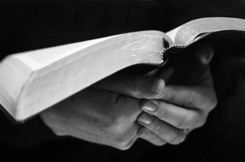 Hospice chaplain holding scripture book
