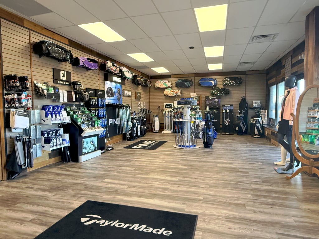 The pro shop: walls of golf bags, gloves, and balls with PING, FootJoy, and TaylorMade displays