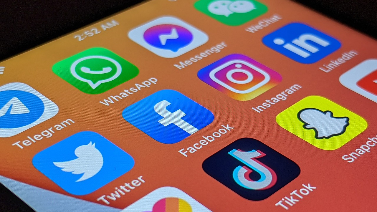Phone screen displaying social media apps like TikTok, Instagram, and YouTube, and Facebook
