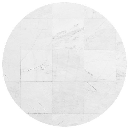 A circular arrangement of white marble tiles with faint gray veins and subtle cracks, forming a seamless patterned surface—perfect for elevating any kitchen remodel.