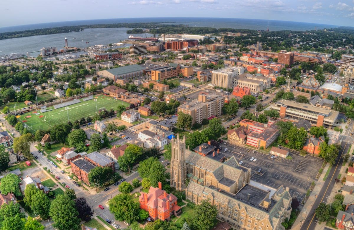 aerial view of a city with a large body of water and a football field