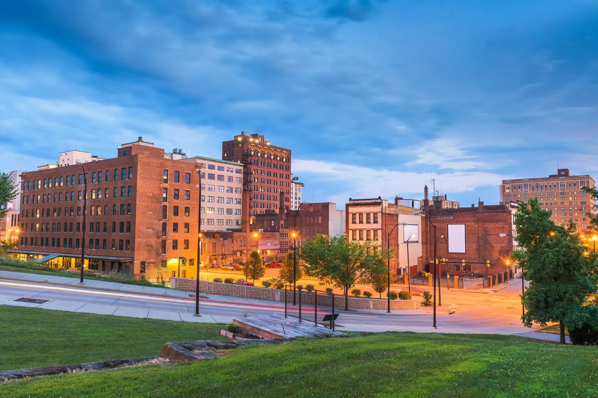 a city street with buildings and a grassy area