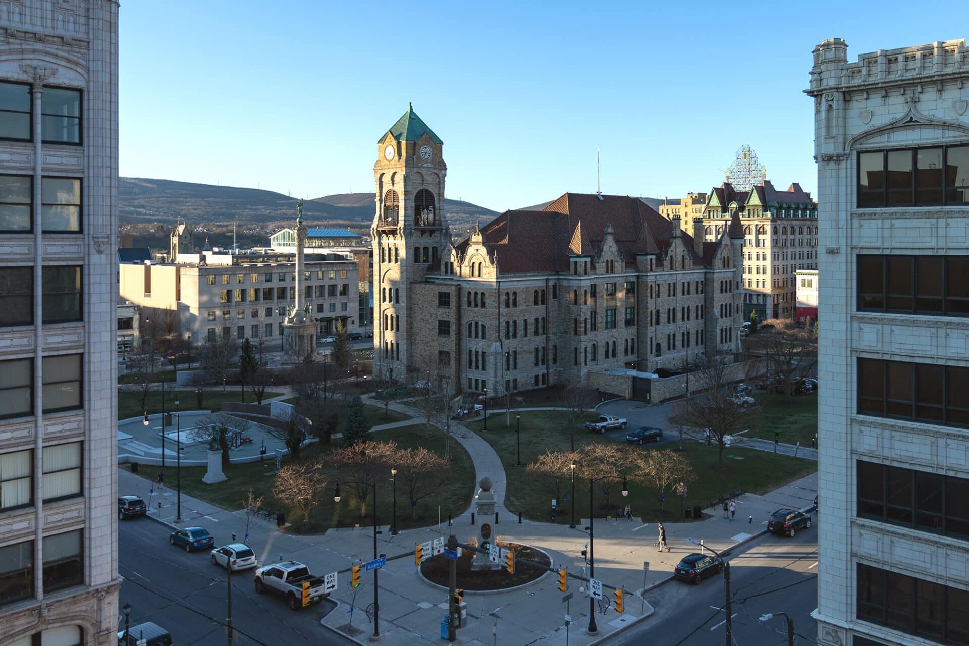 A city street with historic buildings and a park