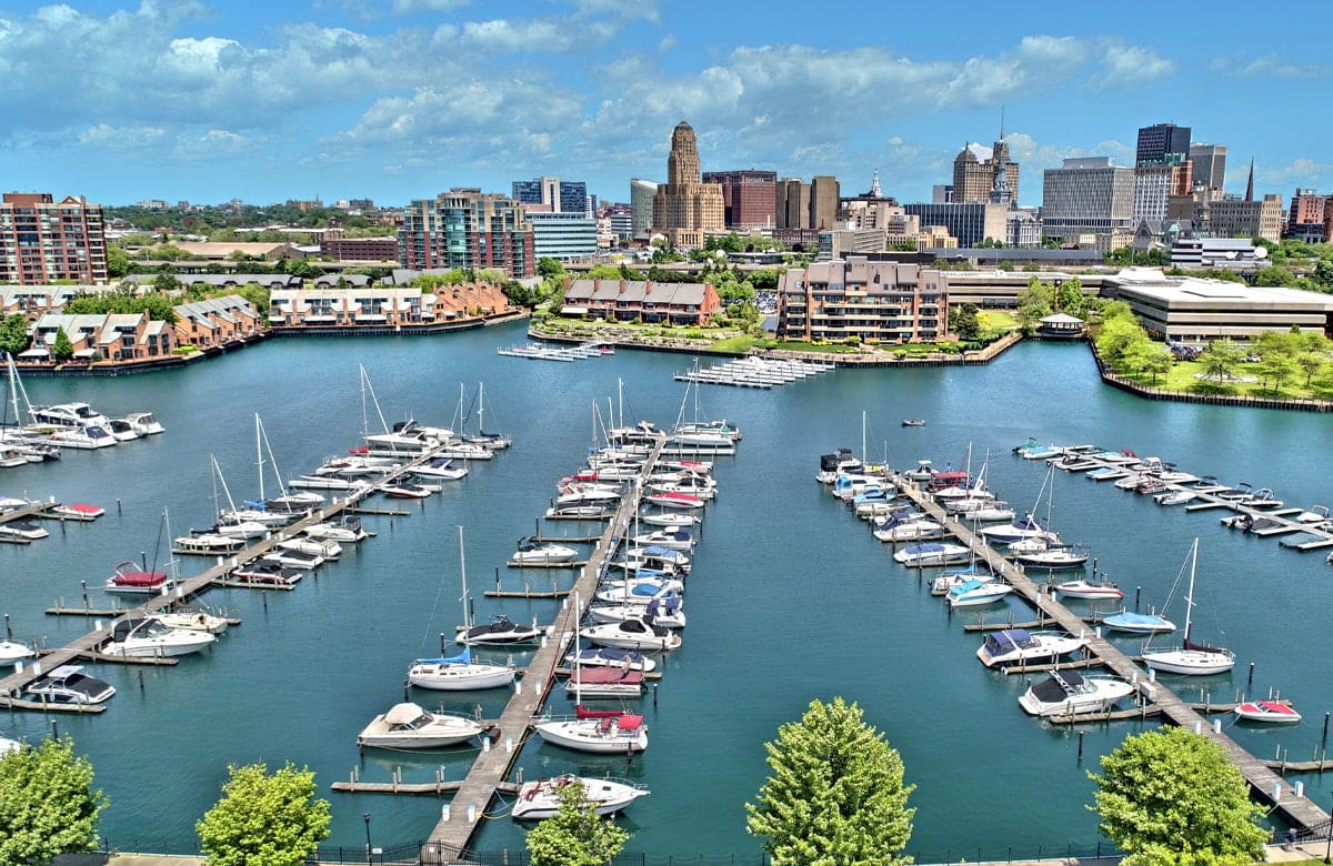 A marina with boats docked in front of a city skyline