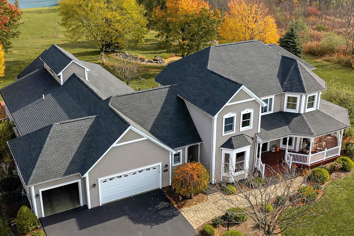 A large house with a gray roof and white trim. The house has a two-car garage.