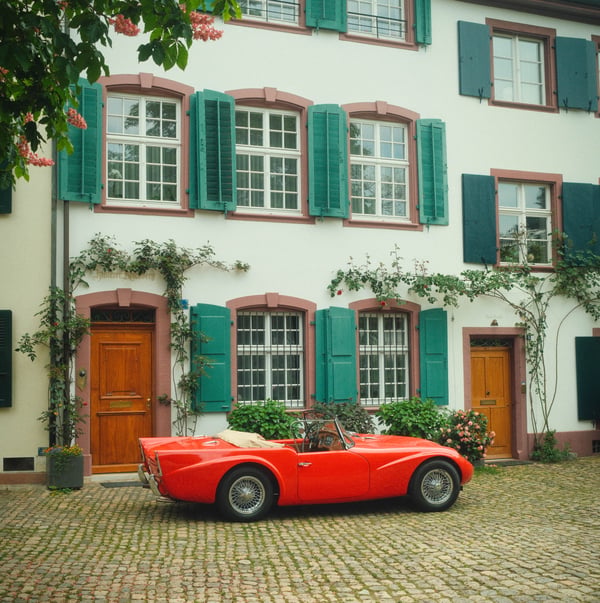 Red Old Timer. Bernoullistrasse, Basel, Switzerland, 2:26 PM, Wednesday, 1 May 2024. Fujifilm X100VI, flash off, f/5.6 at 1/480 at Auto ISO 500. Reggie's Portra + Luminar Neo.