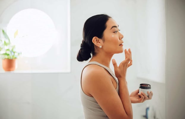 Best Night Cream for Aging Skin. Photo of woman using facial cream.