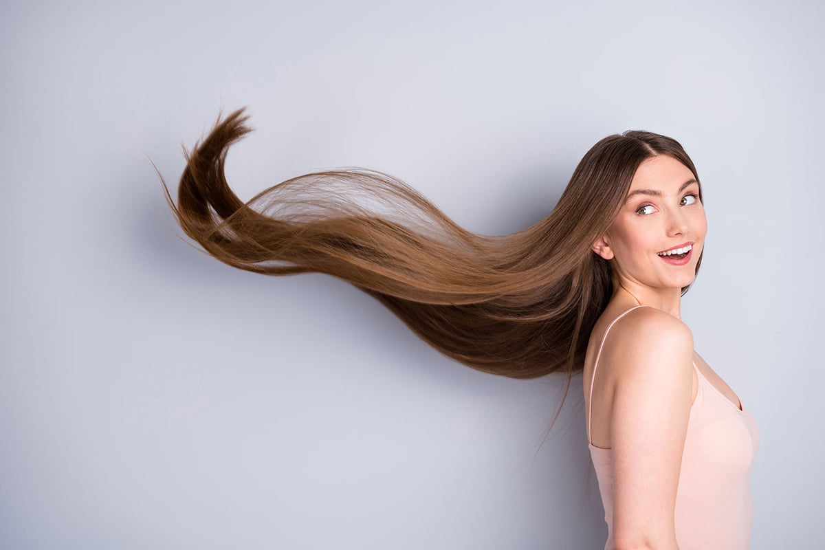 Revive Your Locks: The Best Hair Treatments. Close-up profile side view portrait of her she nice-looking attractive pretty cheerful well-groomed brown-haired girl wind blowing silky flawless hair isolated on light gray pastel color background