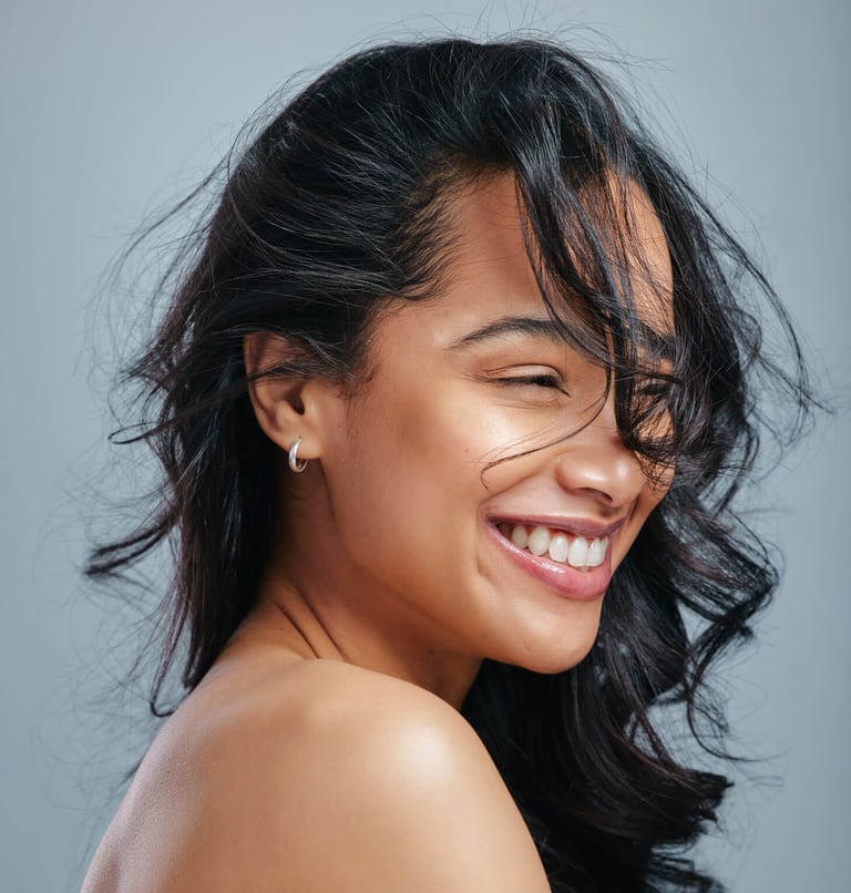 How To Take Care of Wavy Hair. Studio shot of an attractive young woman posing against a grey background stock photo