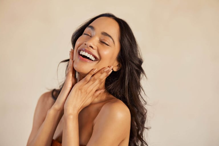 Spotlight on Yon-Ka Skincare. Beautiful laughing woman touching her skin with joy stock photo.
